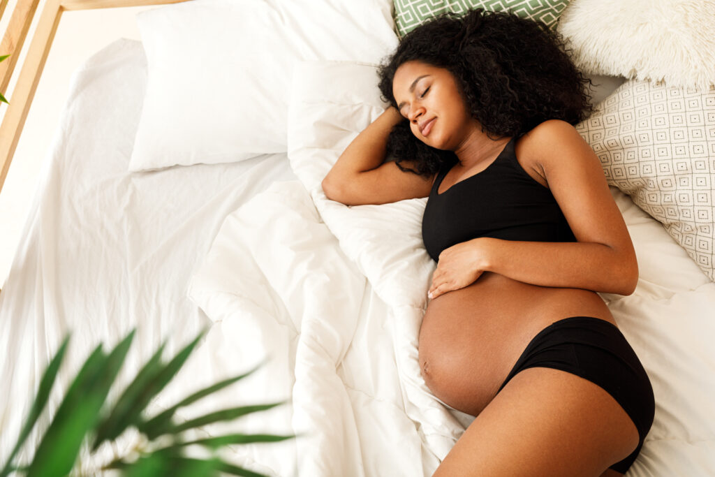 Pregnant woman sleeping in bedroom at home